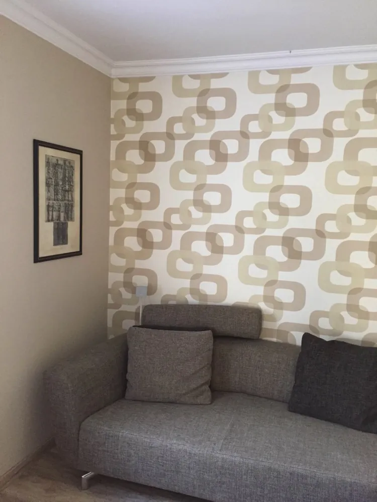 Wohnzimmer mit gemusterter Akzentwand und grauem Sofa