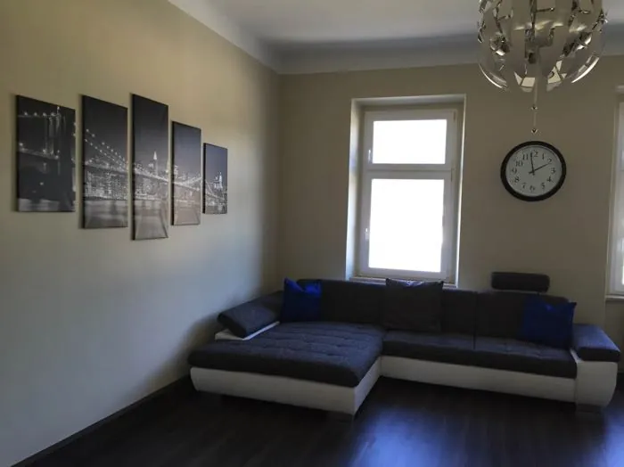 Wohnraum mit dunklem Sofa und ruhigen, hellgrauen Wänden
